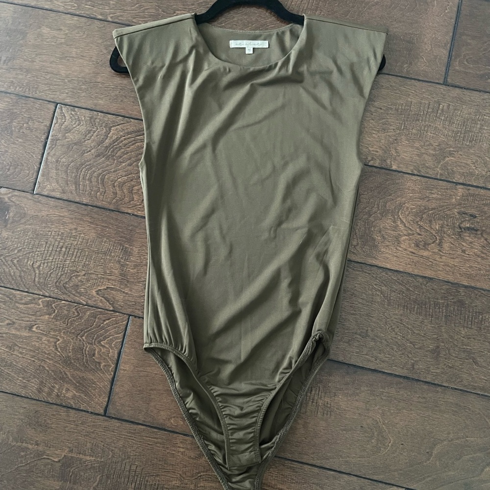 Sleeveless bodysuit with shoulder pads.